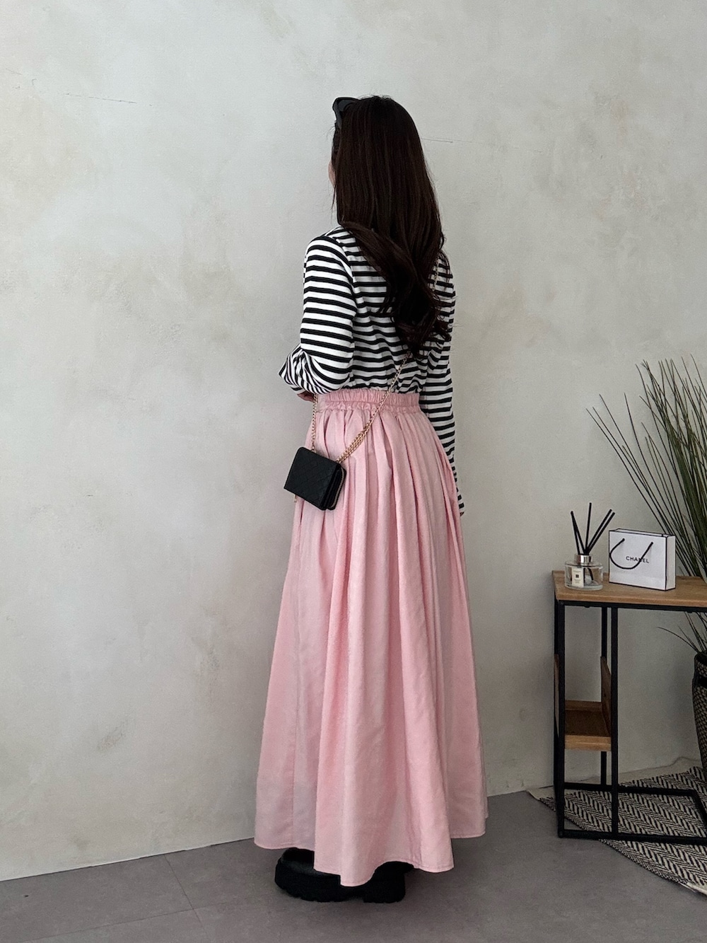 ブラック系のブーツ、ピンク系のスカートを着用したレディースの冬コーディネートの2枚目の写真