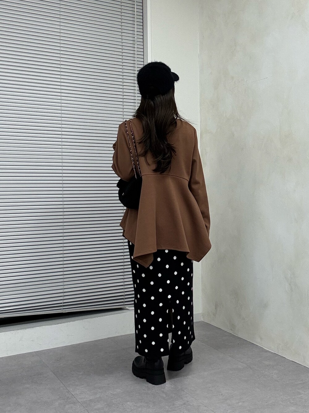 ブラウン系のTシャツ/カットソー、ブラック系のスカート、ブラック系のブーツを着用したレディースの秋コーディネートの3枚目の写真