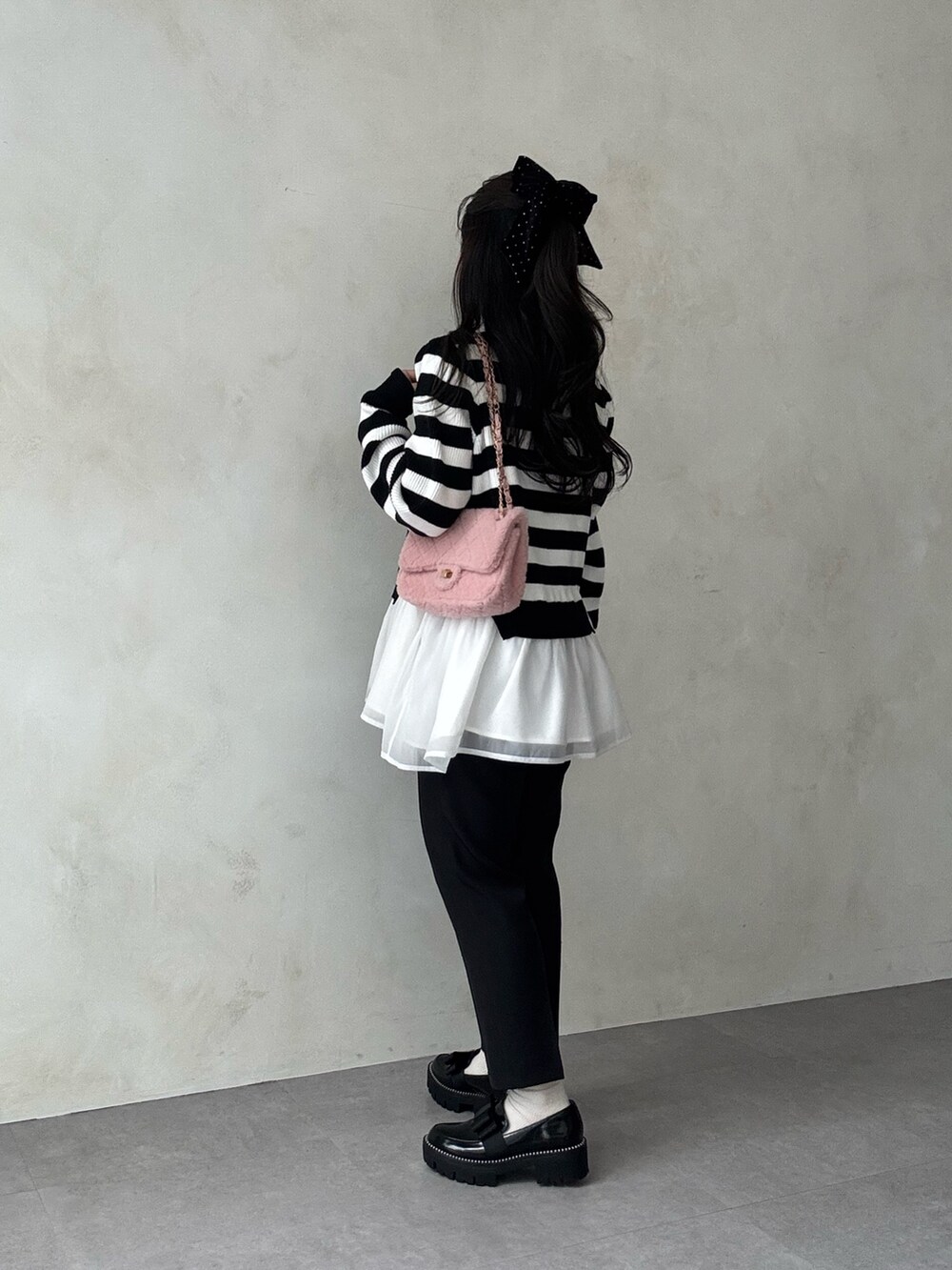 ホワイト系のニット/セーター、ブラック系のその他パンツ、ピンク系のショルダーバッグを着用したレディースの秋コーディネートの2枚目の写真