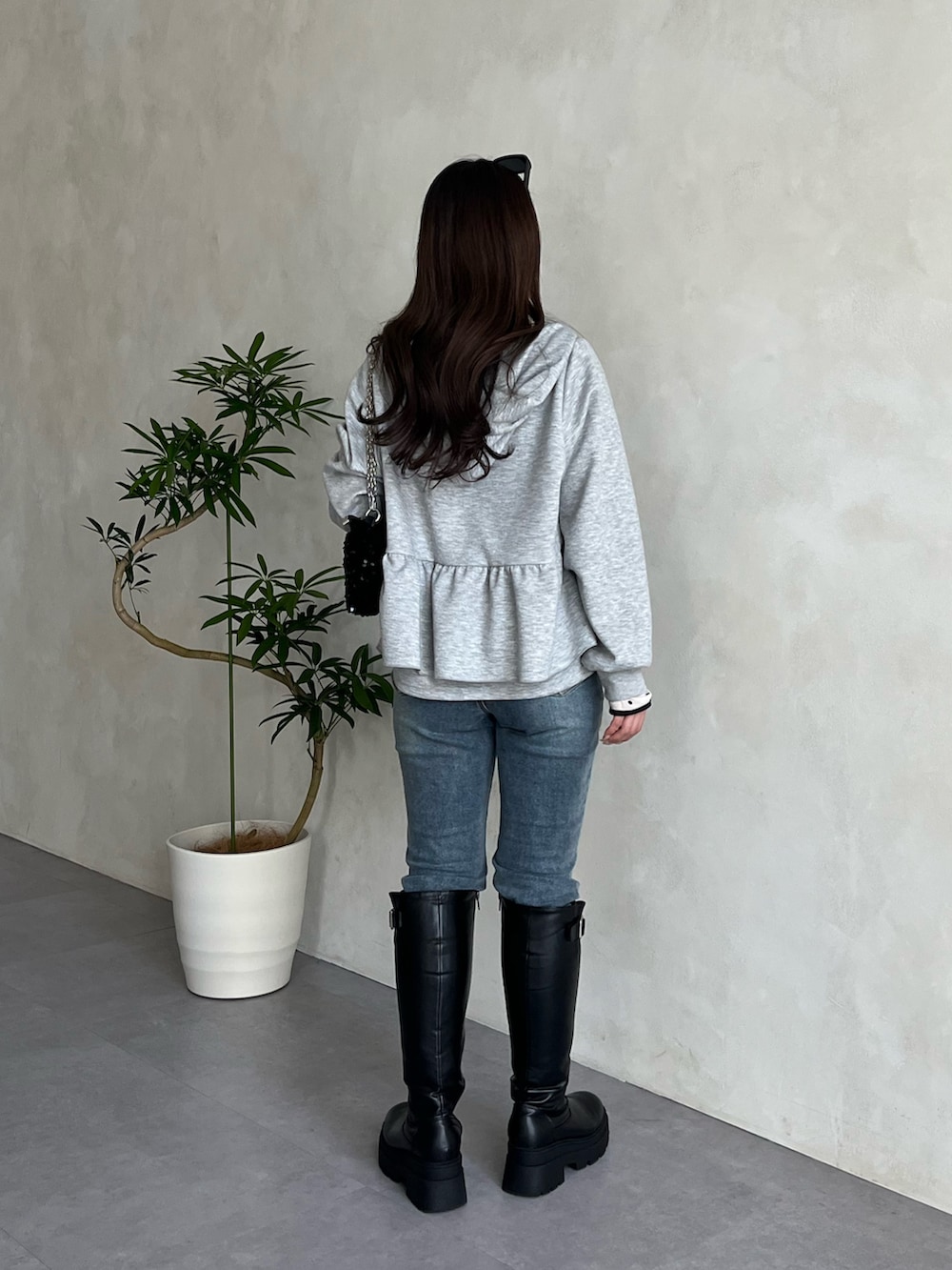 ホワイト系のTシャツ/カットソー、ブルー系のデニムパンツ、ブラック系のショルダーバッグを着用したレディースの冬コーディネートの3枚目の写真