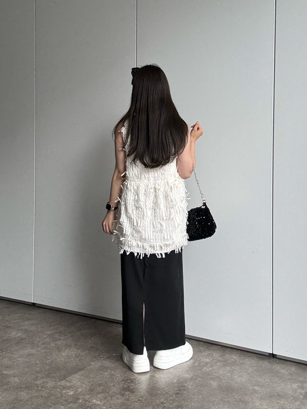 ブラック系のスカート、ホワイト系のシャツ/ブラウス、ブラック系のショルダーバッグを着用したレディースの夏コーディネートの2枚目の写真