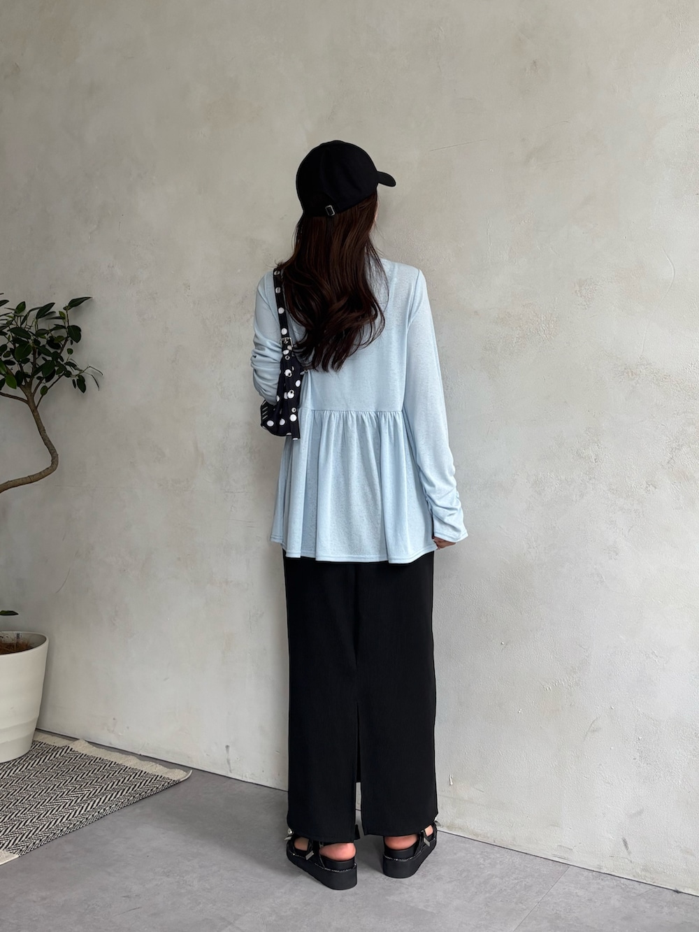 ブラック系のスカート、ブルー系のTシャツ/カットソー、ブラック系のサンダルを着用したレディースの春コーディネートの3枚目の写真