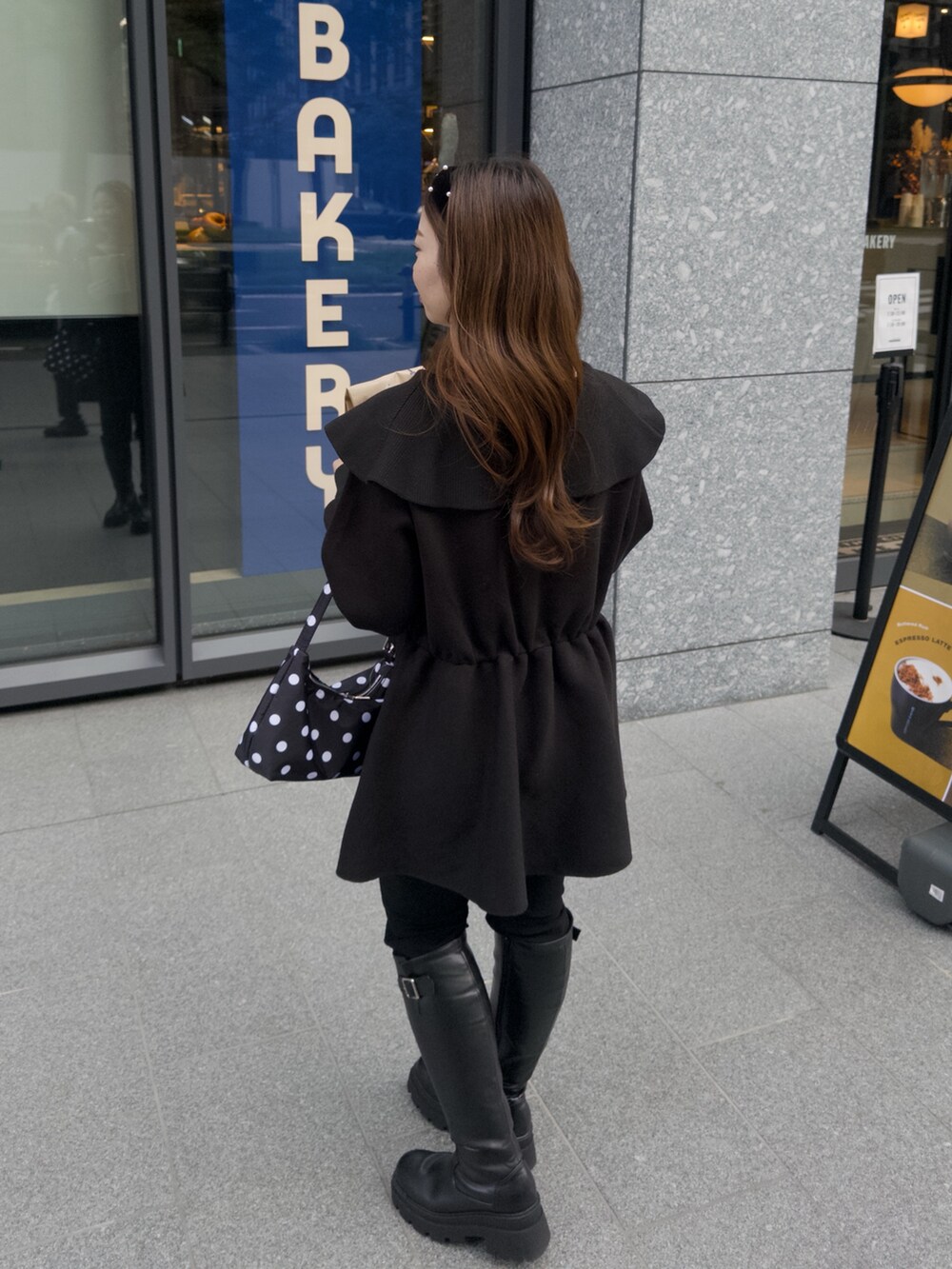 ブラック系のニット/セーター、ブラック系のその他パンツ、ブラック系のブーツを着用したレディースの秋コーディネートの2枚目の写真