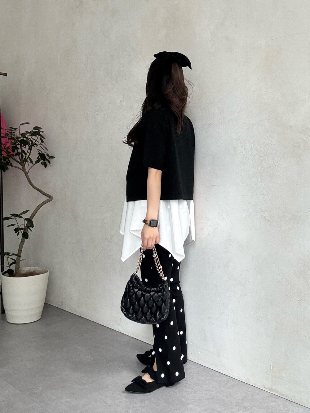 ブラック系のパンプス、ホワイト系のキャミソール、ブラック系のカーディガン/ボレロを着用したレディースの春コーディネートの2枚目の写真