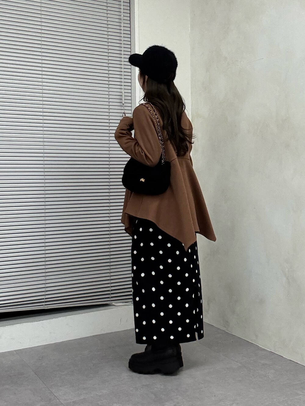 ブラウン系のTシャツ/カットソー、ブラック系のスカート、ブラック系のブーツを着用したレディースの秋コーディネートの2枚目の写真