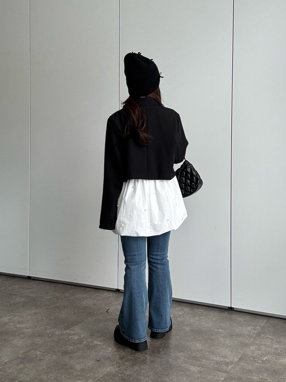 ブラック系のテーラードジャケット、ホワイト系のTシャツ/カットソー、ブルー系のデニムパンツを着用したレディースの秋コーディネートの2枚目の写真