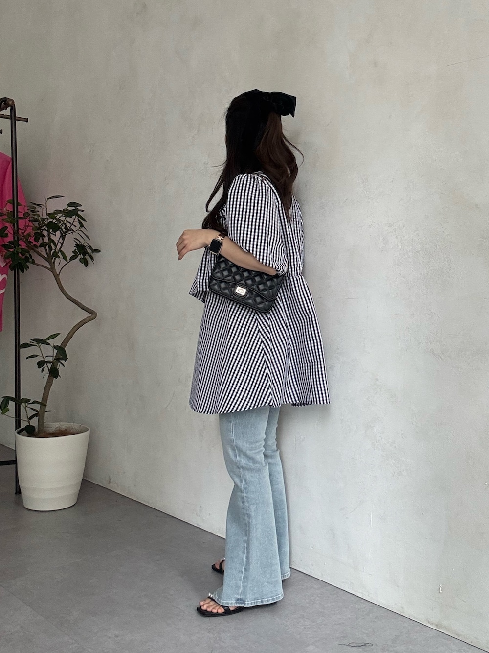 ブラック系のサンダル、ブルー系のデニムパンツ、ブラック系のトートバッグを着用したレディースの春コーディネートの2枚目の写真