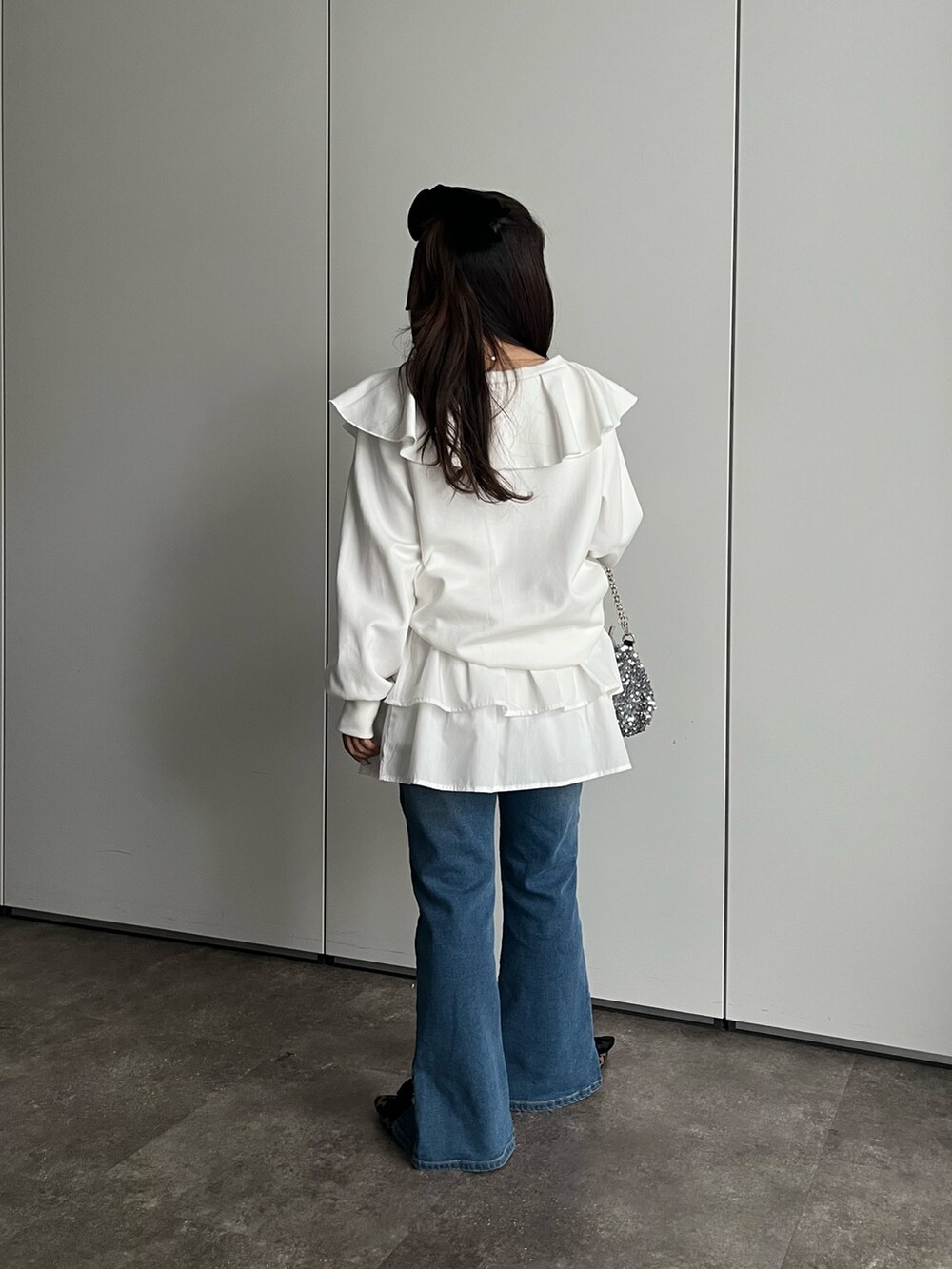 ホワイト系のスウェット、ホワイト系のスカート、シルバー系のショルダーバッグを着用したレディースの秋コーディネートの2枚目の写真