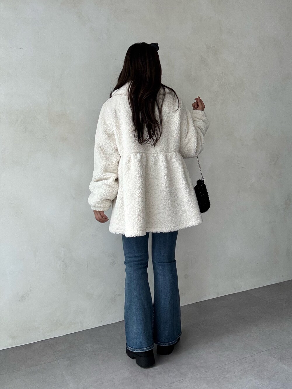 ホワイト系のその他アウター、ブルー系のデニムパンツ、ブラック系のニット/セーターを着用したレディースの秋コーディネートの3枚目の写真