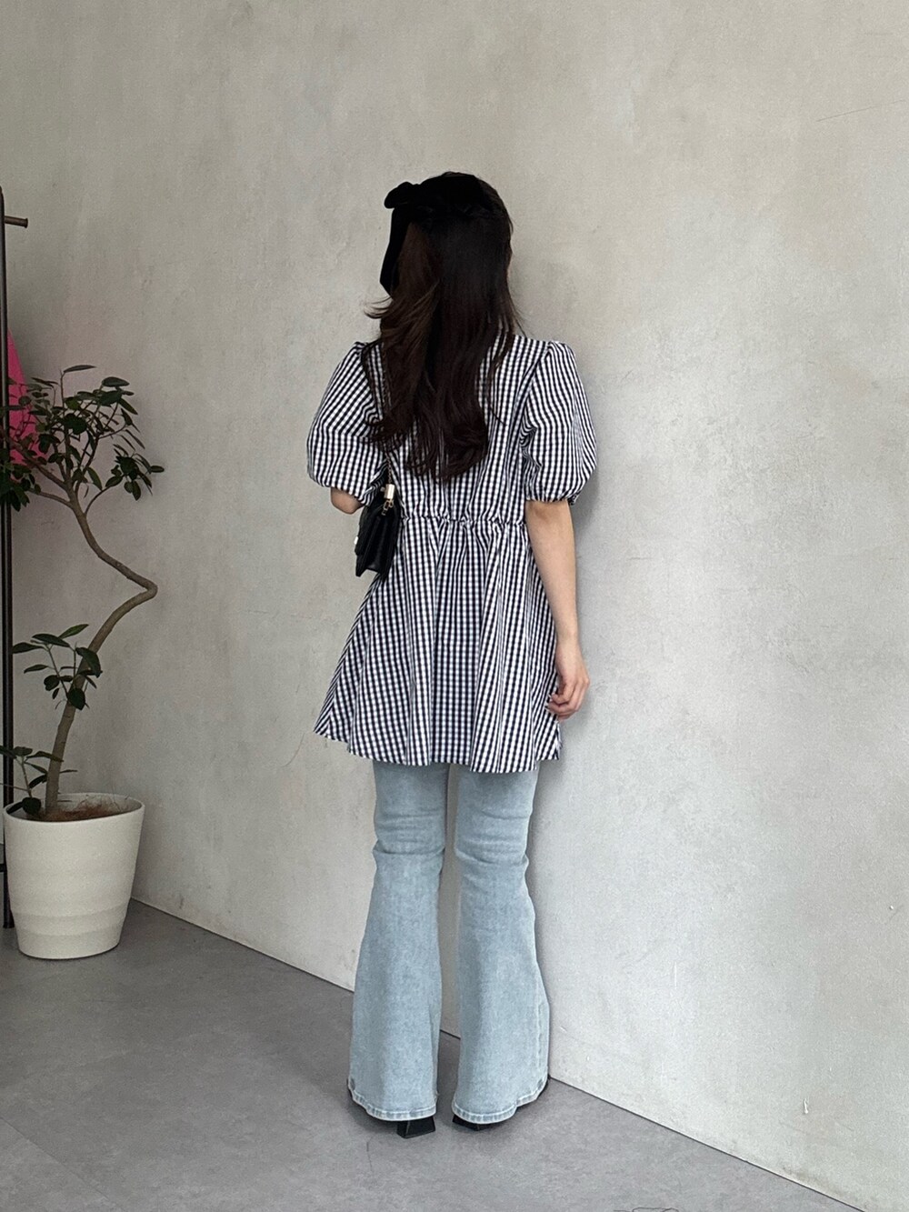 ブラック系のサンダル、ブルー系のデニムパンツ、ブラック系のトートバッグを着用したレディースの春コーディネートの3枚目の写真