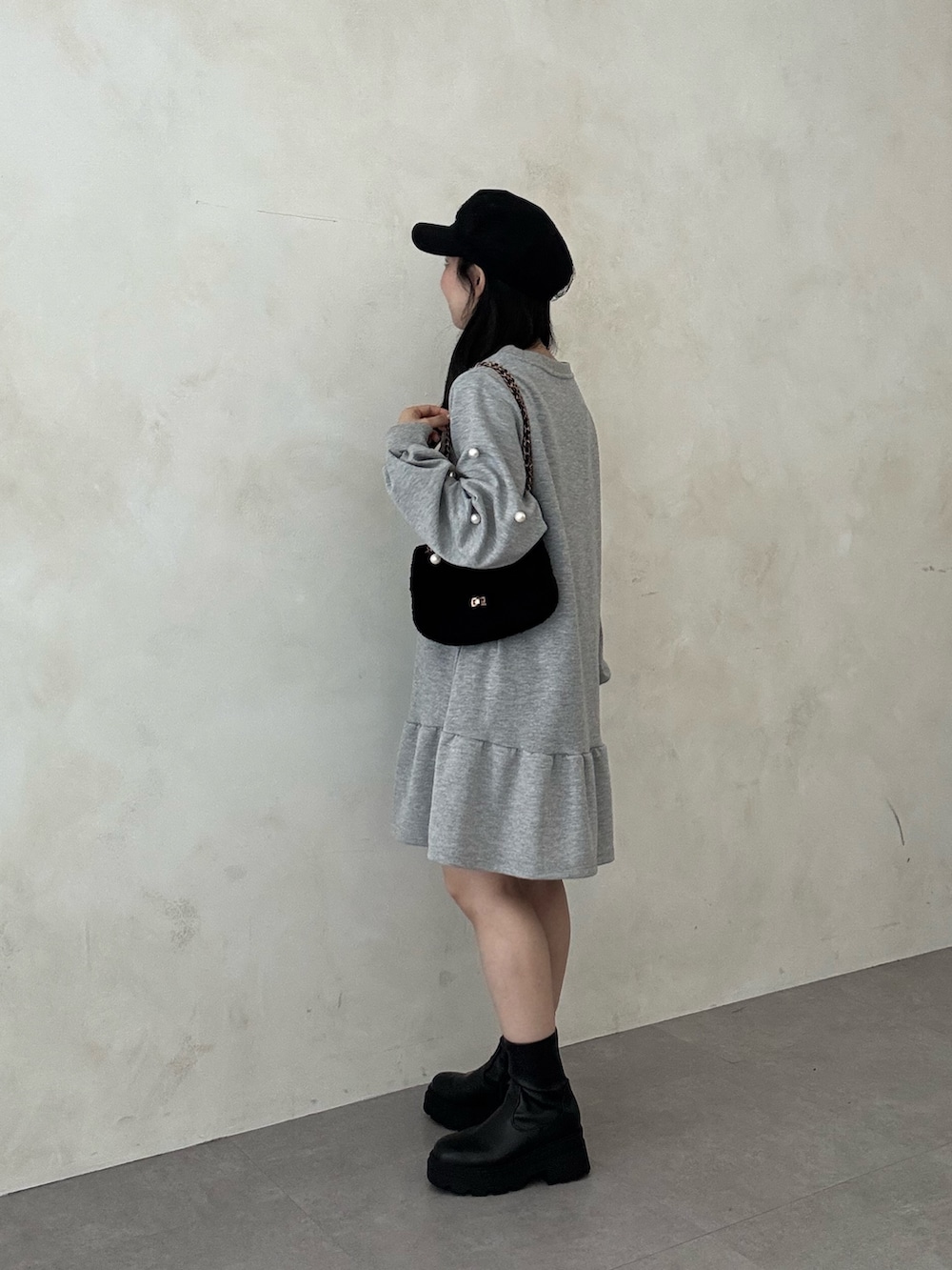 ブラック系のブーツ、ブラック系のショルダーバッグ、グレー系のスウェットを着用したレディースの秋コーディネートの2枚目の写真
