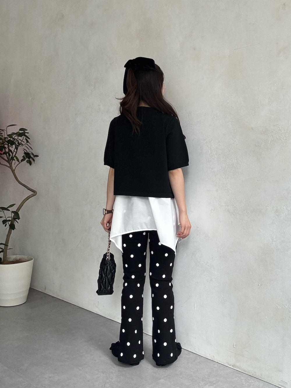 ブラック系のパンプス、ホワイト系のキャミソール、ブラック系のカーディガン/ボレロを着用したレディースの春コーディネートの3枚目の写真