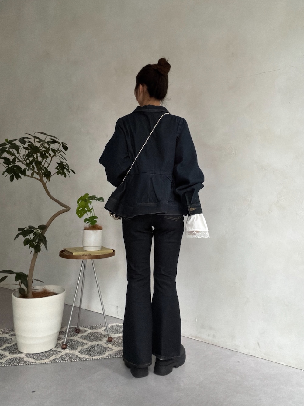 ブルー系のデニムパンツ、ブラック系のブーツ、ブラック系のニット/セーターを着用したレディースの秋コーディネートの3枚目の写真