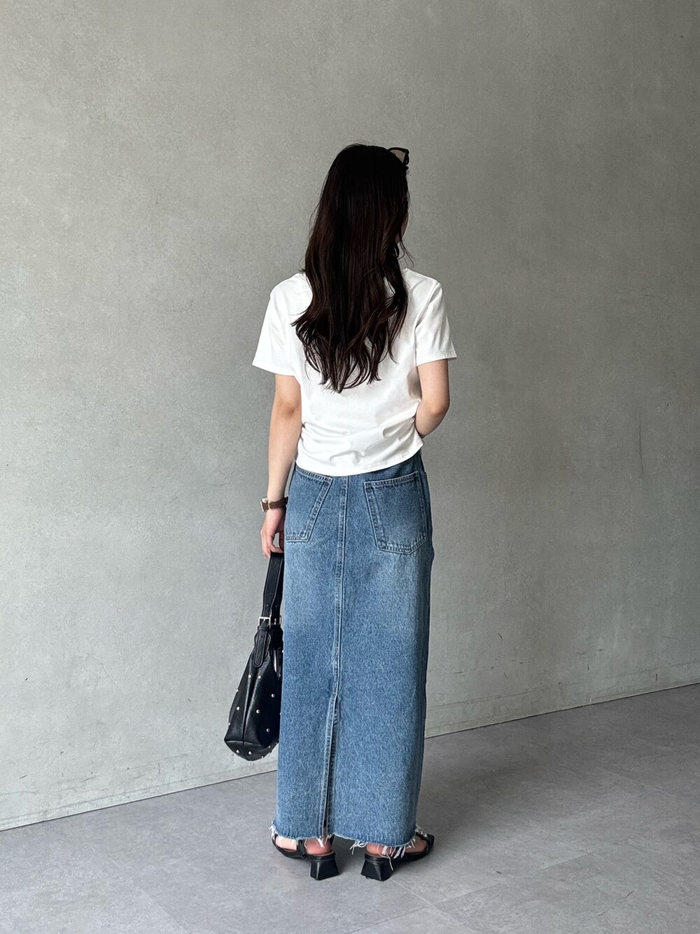 ホワイト系のTシャツ/カットソー、ブルー系のスカート、ブラック系のサンダルを着用したレディースの夏コーディネートの3枚目の写真