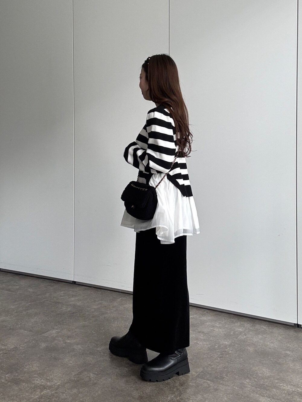 ホワイト系のニット/セーター、ブラック系のスカート、ブラック系のショルダーバッグを着用したレディースの秋コーディネートの2枚目の写真