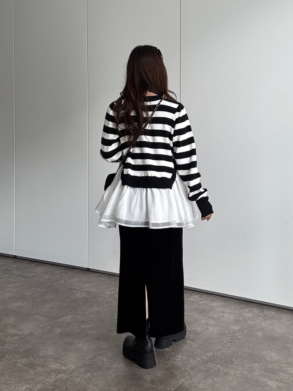 ホワイト系のニット/セーター、ブラック系のスカート、ブラック系のショルダーバッグを着用したレディースの秋コーディネートの3枚目の写真