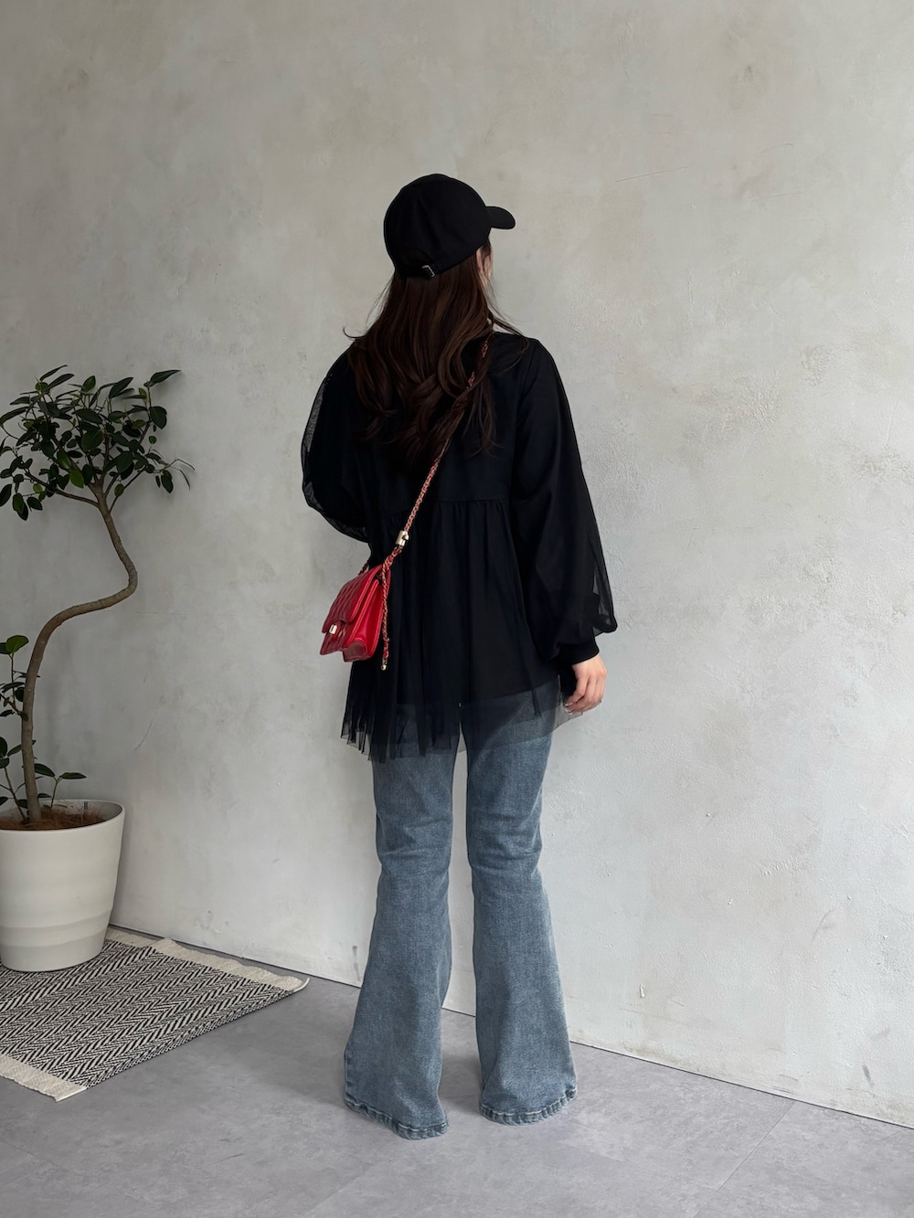 ブルー系のデニムパンツ、ホワイト系のTシャツ/カットソー、レッド系のトートバッグを着用したレディースの春コーディネートの3枚目の写真