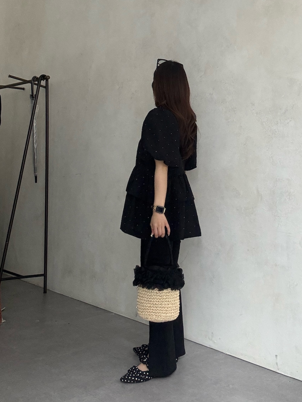 ブラック系のその他パンツ、ブラック系のパンプス、ベージュ系のかごバッグを着用したレディースの春コーディネートの2枚目の写真