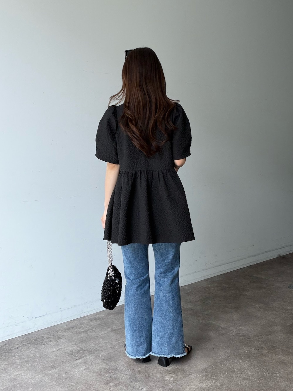 ブルー系のデニムパンツ、ブラック系のサンダル、ブラック系のシャツ/ブラウスを着用したレディースの夏コーディネートの3枚目の写真