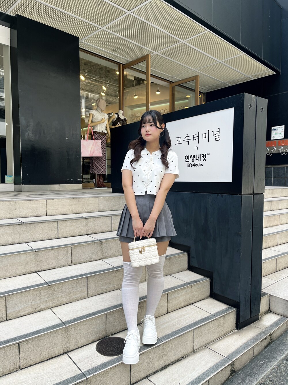 ホワイト系のニット/セーター、グレー系のその他パンツ、ホワイト系のショルダーバッグを着用したレディースの夏コーディネートの2枚目の写真