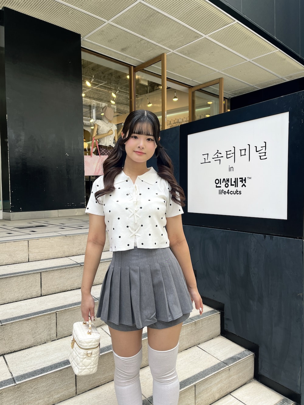 ホワイト系のニット/セーター、グレー系のその他パンツ、ホワイト系のショルダーバッグを着用したレディースの夏コーディネートの8枚目の写真