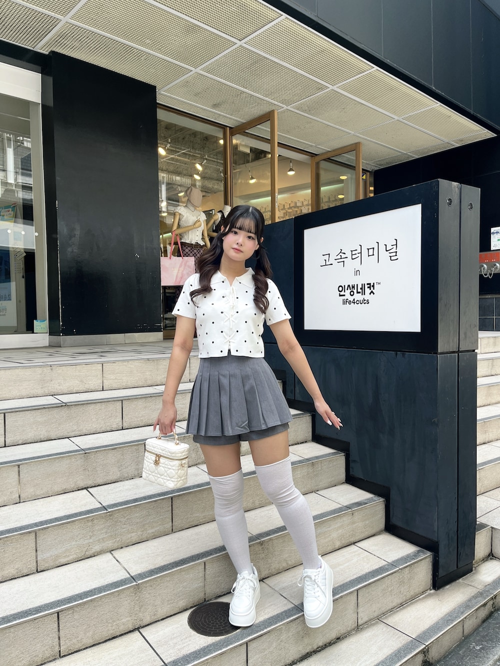 ホワイト系のニット/セーター、グレー系のその他パンツ、ホワイト系のショルダーバッグを着用したレディースの夏コーディネートの7枚目の写真