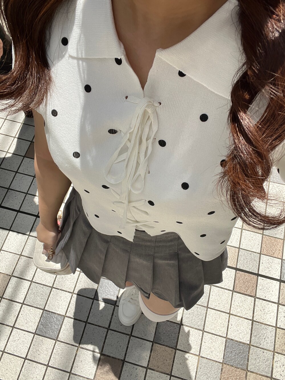 ホワイト系のニット/セーター、グレー系のその他パンツ、ホワイト系のショルダーバッグを着用したレディースの夏コーディネートの9枚目の写真