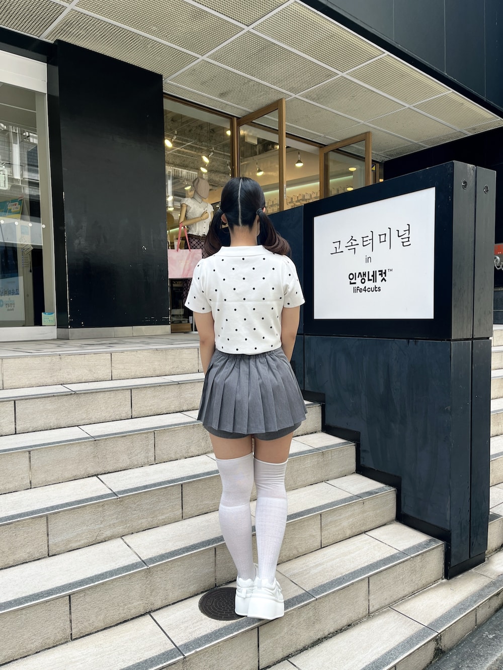 ホワイト系のニット/セーター、グレー系のその他パンツ、ホワイト系のショルダーバッグを着用したレディースの夏コーディネートの4枚目の写真