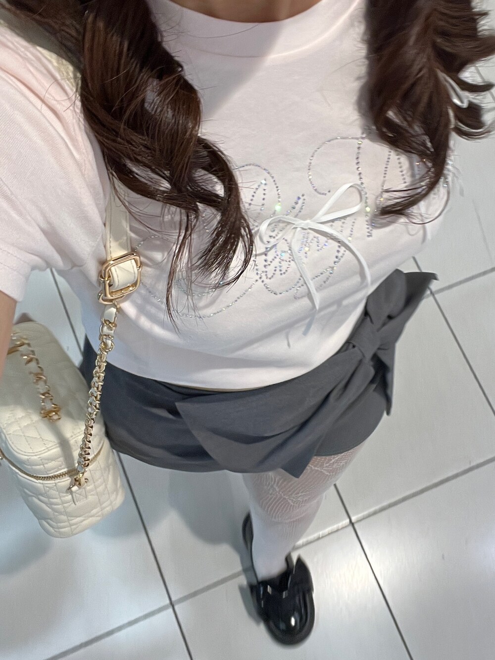 ピンク系のTシャツ/カットソー、ホワイト系のショルダーバッグ、グレー系のスカートを着用したレディースの夏コーディネートの6枚目の写真