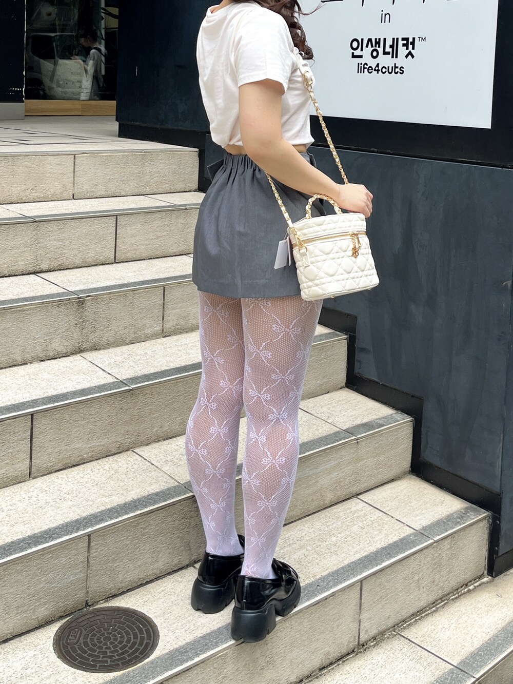 ピンク系のTシャツ/カットソー、ホワイト系のショルダーバッグ、グレー系のスカートを着用したレディースの夏コーディネートの4枚目の写真