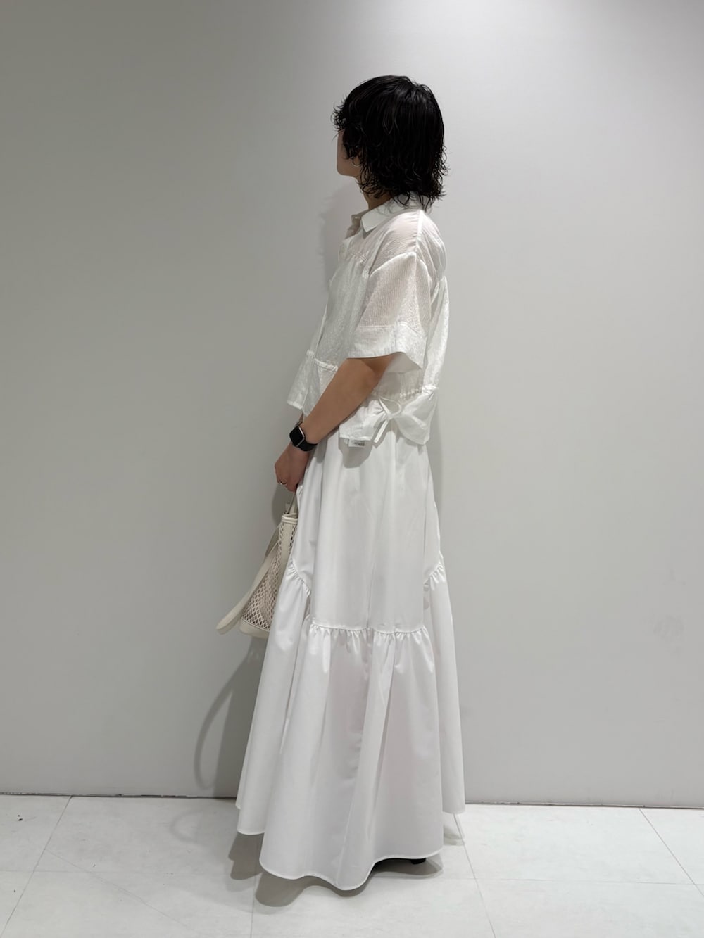 ホワイト系のシャツ/ブラウス、ホワイト系のスカート、ブラウン系のサンダルを着用したレディースの夏コーディネートの3枚目の写真