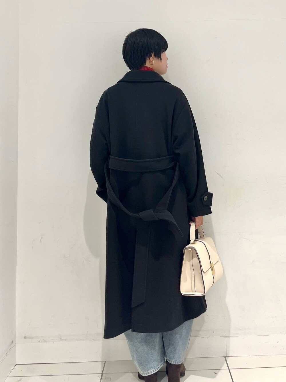 ブラック系のその他アウター、ブラウン系のブーツ、レッド系のニット/セーターを着用したレディースの秋コーディネートの3枚目の写真