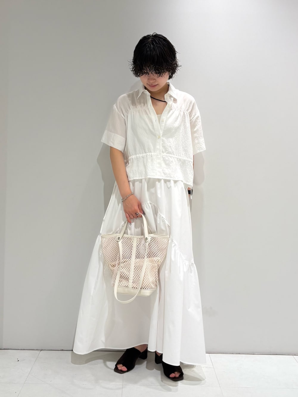 ホワイト系のシャツ/ブラウス、ホワイト系のスカート、ブラウン系のサンダルを着用したレディースの夏コーディネートの2枚目の写真