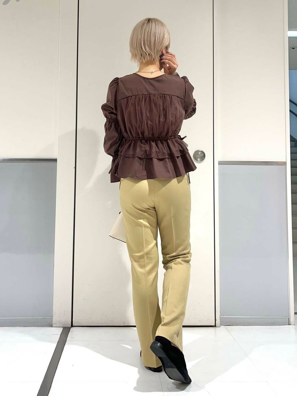 ホワイト系のハンドバッグ、ブラック系のその他シューズ、ブラウン系のシャツ/ブラウスを着用したレディースの秋コーディネートの2枚目の写真