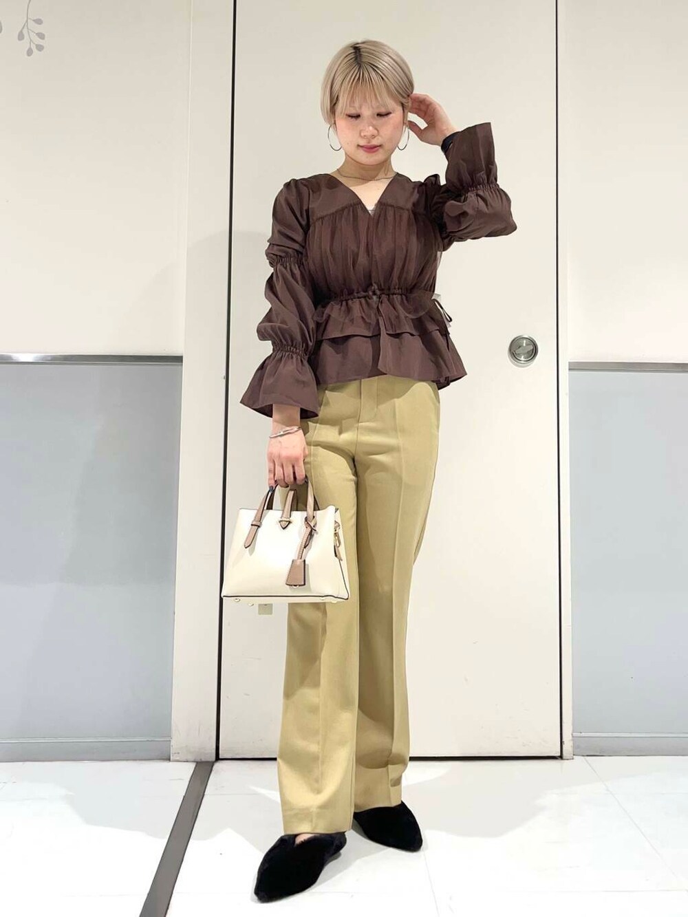 ホワイト系のハンドバッグ、ブラック系のその他シューズ、ブラウン系のシャツ/ブラウスを着用したレディースの秋コーディネートの3枚目の写真