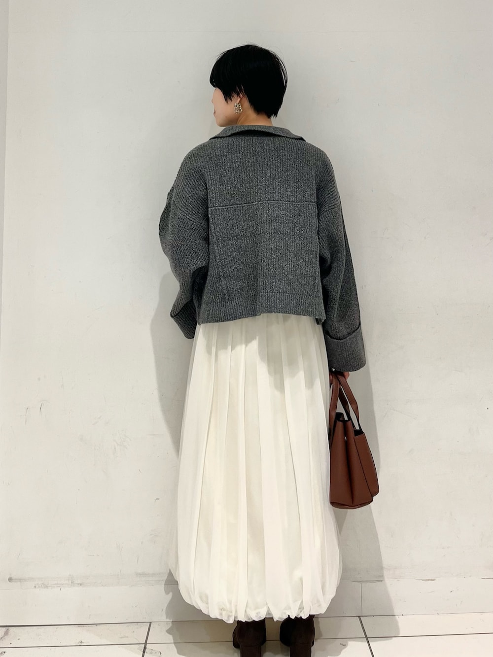 グレー系のその他アウター、ホワイト系のTシャツ/カットソー、ホワイト系のスカートを着用したレディースの秋コーディネートの3枚目の写真