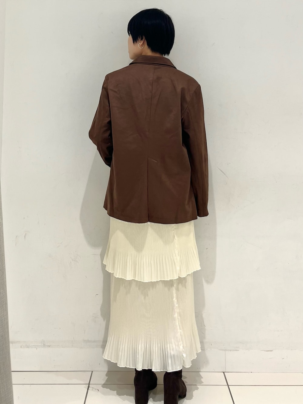 ブラウン系のその他アウター、ホワイト系のスカート、ブラウン系のブーツを着用したレディースの秋コーディネートの3枚目の写真