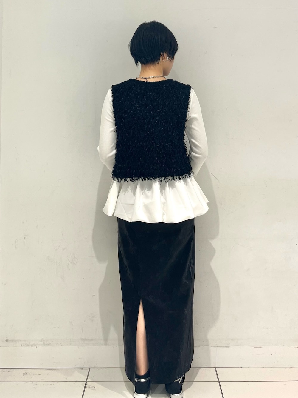 ホワイト系のニット/セーター、ホワイト系のTシャツ/カットソー、ブラック系のスカートを着用したレディースの秋コーディネートの3枚目の写真