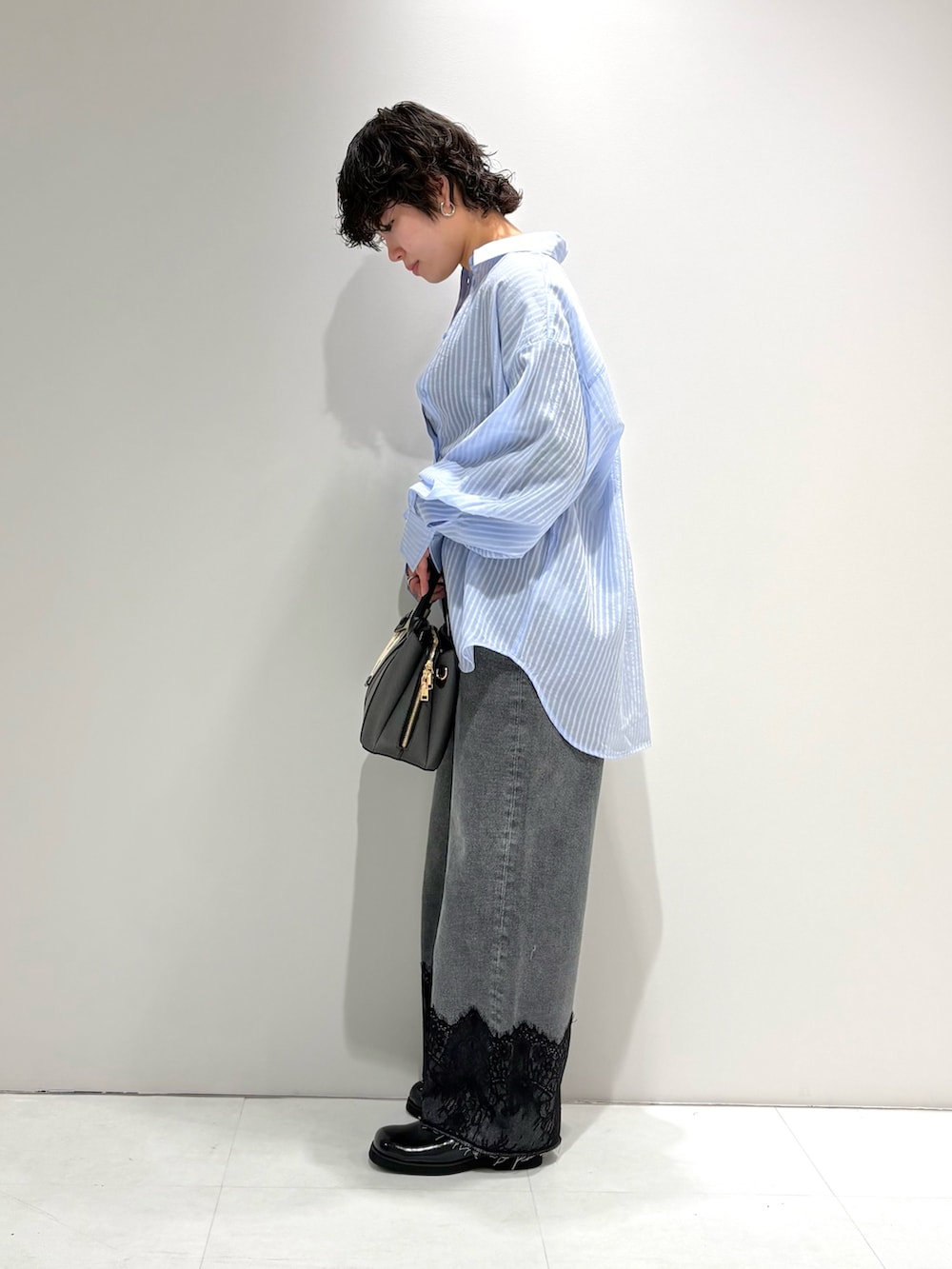 ブルー系のシャツ/ブラウス、グレー系のデニムパンツ、ブラック系のサンダルを着用したレディースの春コーディネートの2枚目の写真