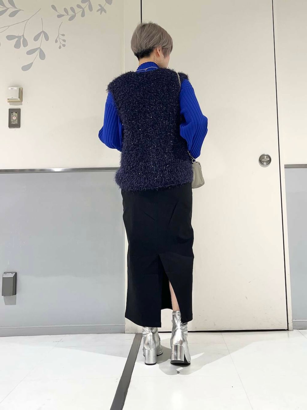 シルバー系のブーツ、ブルー系のベスト、ブルー系のニット/セーターを着用したレディースの冬コーディネートの3枚目の写真