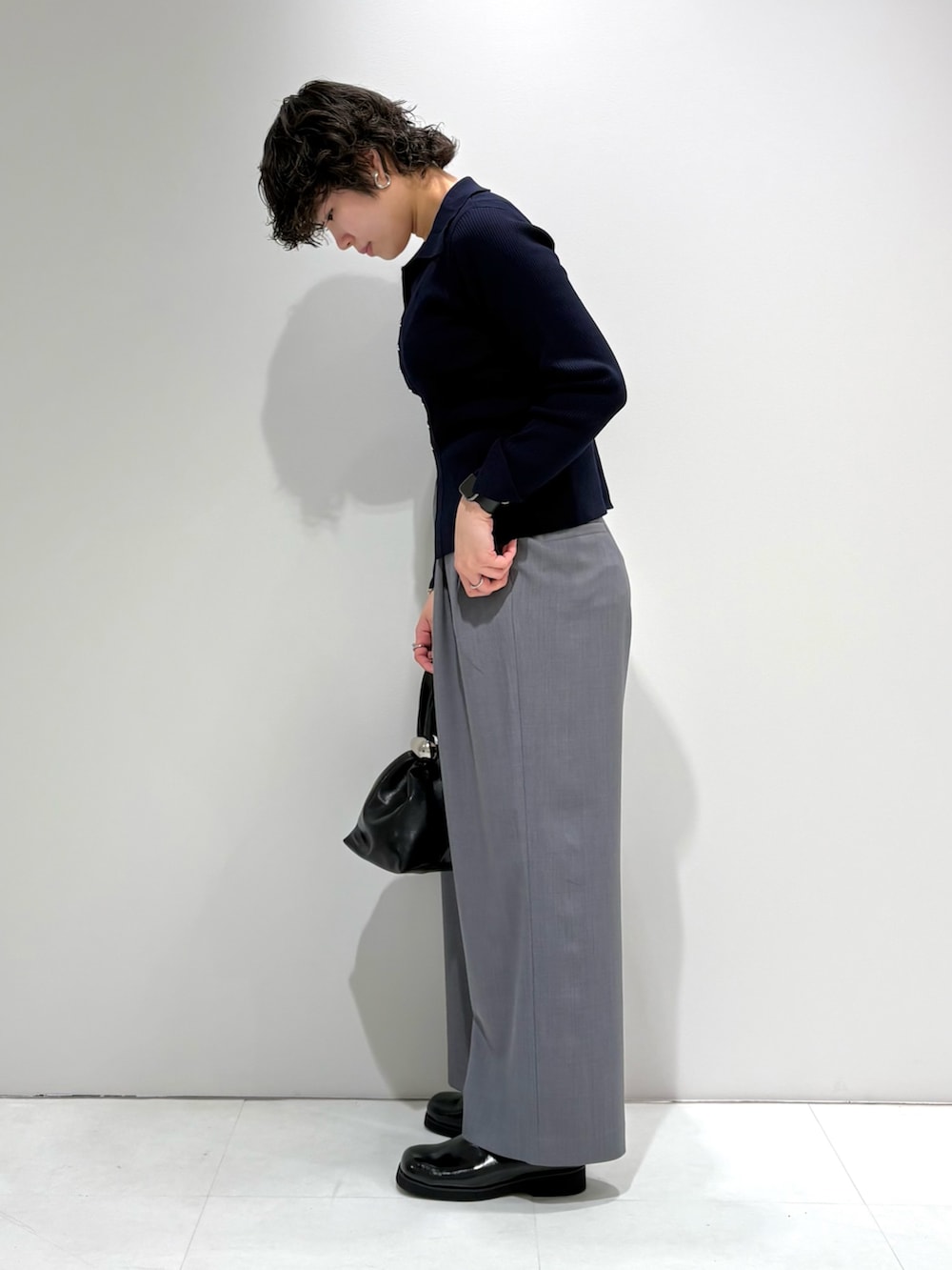 ブルー系のカーディガン/ボレロ、グレー系のスラックス、ブラック系のサンダルを着用したレディースの春コーディネートの2枚目の写真