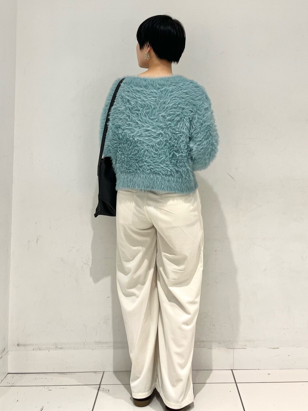 グレー系のニット/セーター、ホワイト系のその他パンツ、ブラウン系のスニーカーを着用したレディースの秋コーディネートの3枚目の写真