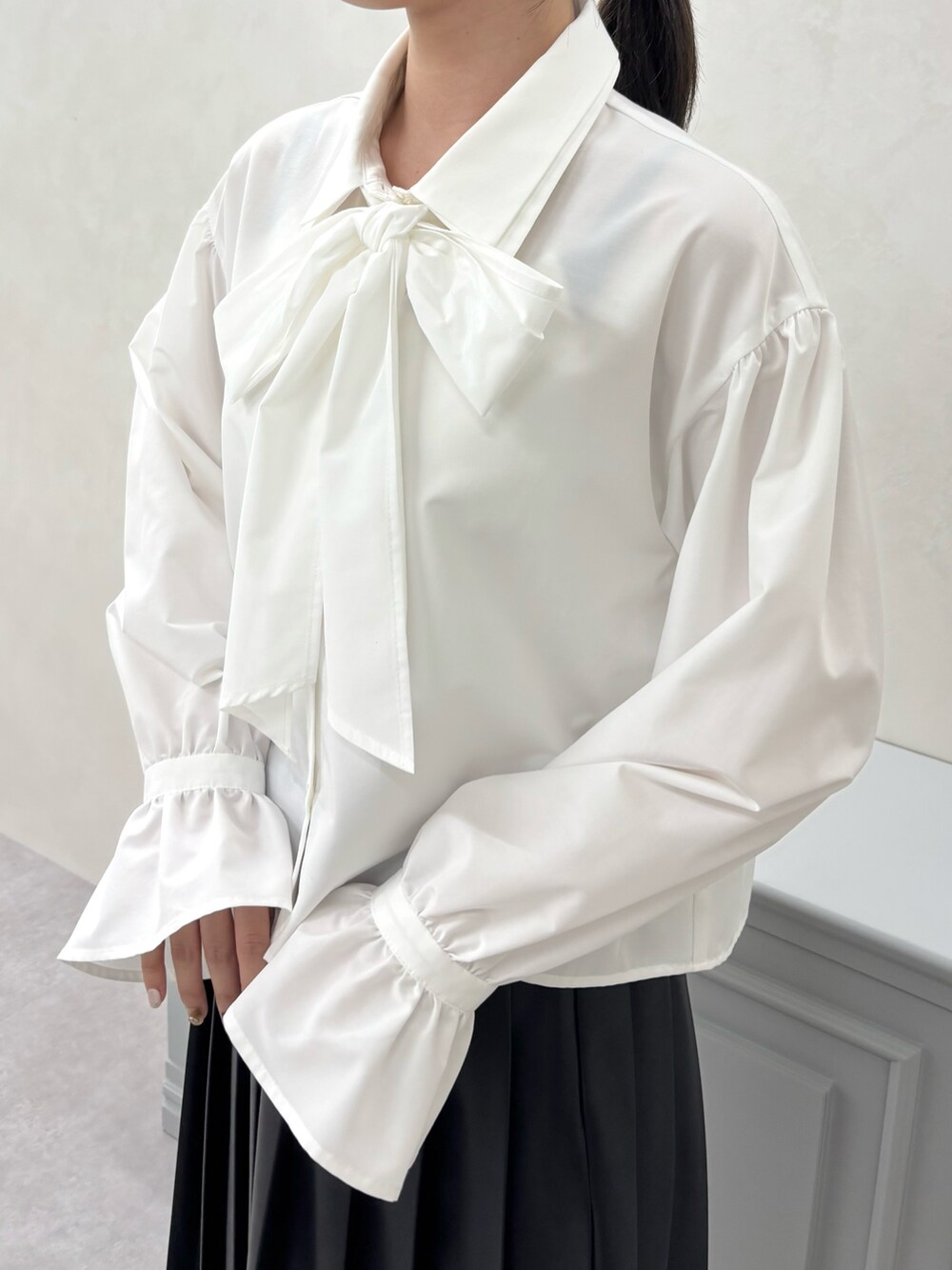 ホワイト系のシャツ/ブラウス、ベージュ系のスカート、ブラウン系のパンプスを着用したレディースの秋コーディネートの4枚目の写真