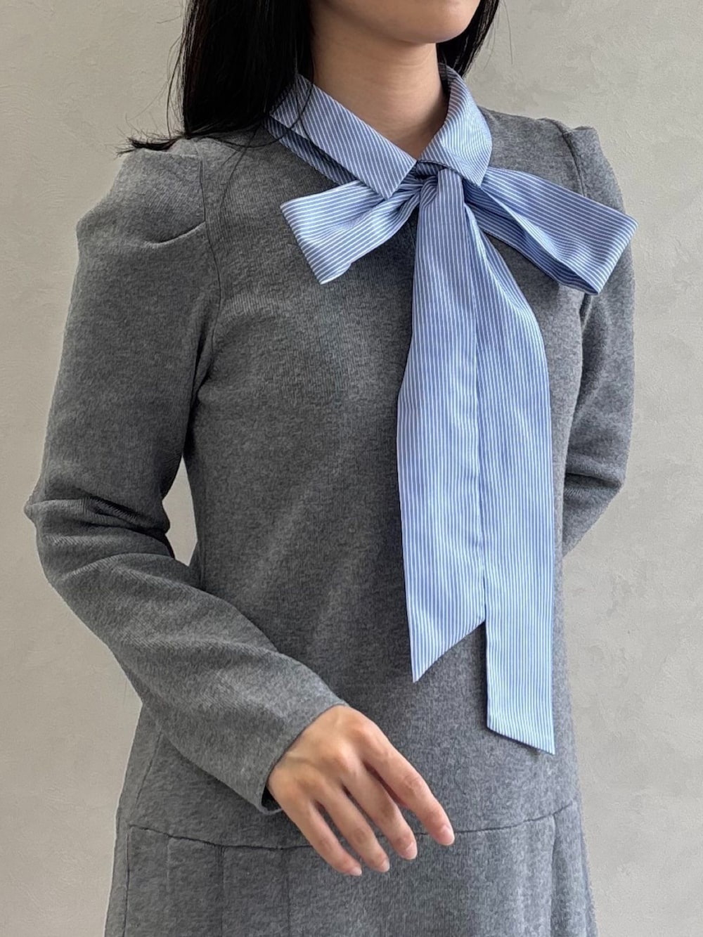 グレー系のワンピース、ブラック系のパンプスを着用したレディースの秋コーディネートの3枚目の写真