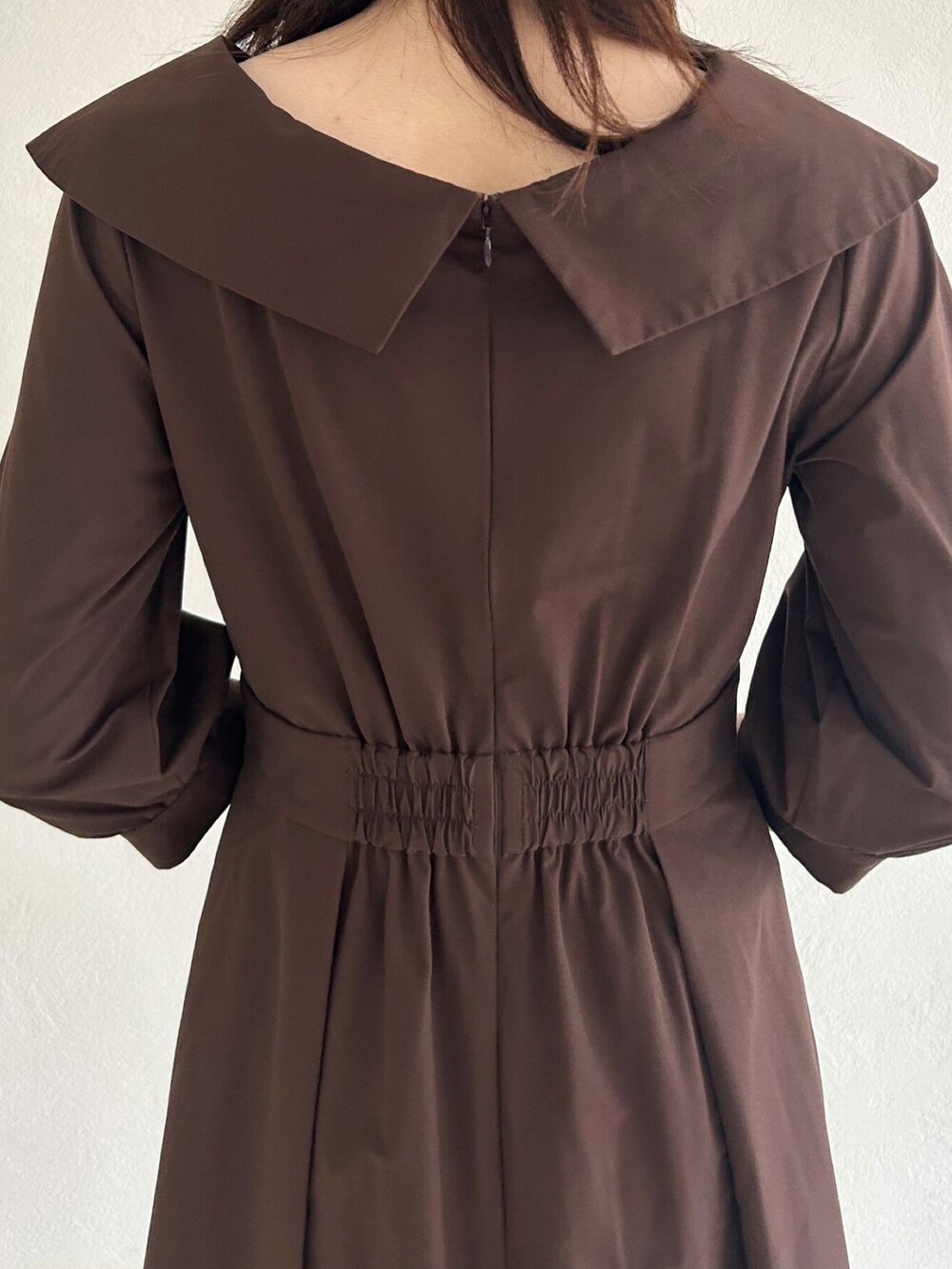 ブラウン系のワンピース、ブラウン系のパンプスを着用したレディースの秋コーディネートの4枚目の写真