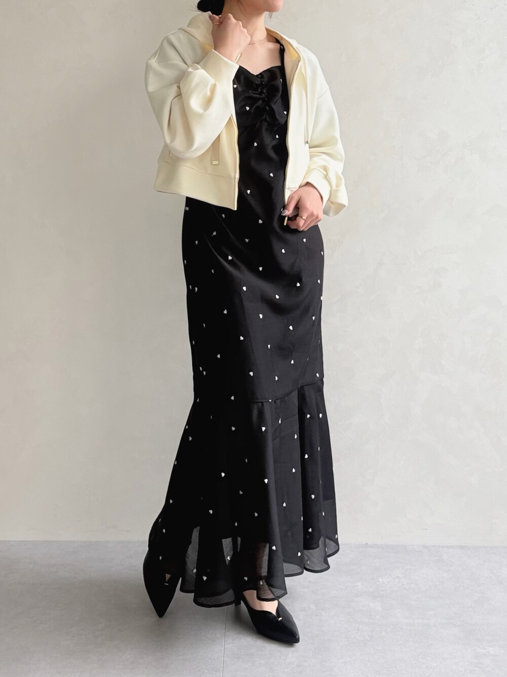 ブラック系のワンピース、イエロー系のパーカーを着用したレディースの春コーディネートの2枚目の写真