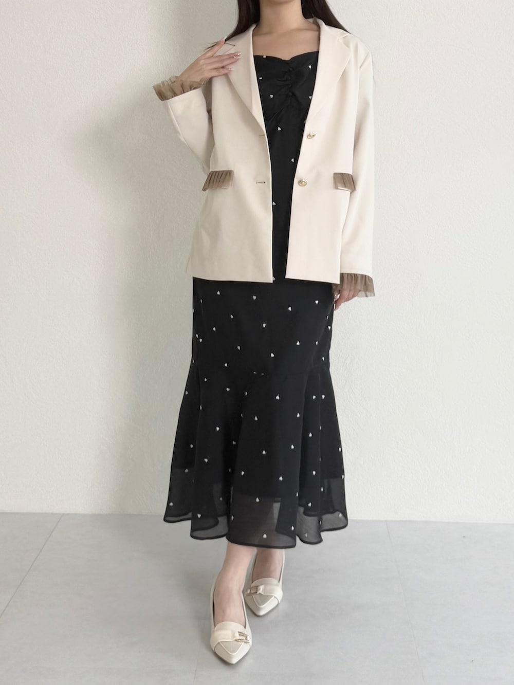 ホワイト系のテーラードジャケット、ブラック系のワンピース、ベージュ系のシューズを着用したレディースの春コーディネートの2枚目の写真