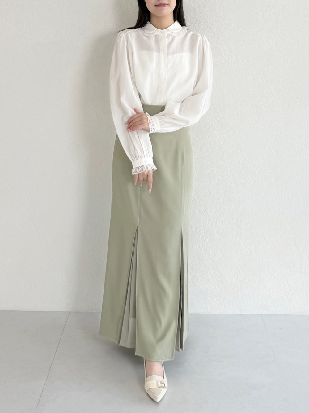 グリーン系のスカート、ベージュ系のシューズ、ホワイト系のシャツ/ブラウスを着用したレディースの春コーディネートの3枚目の写真