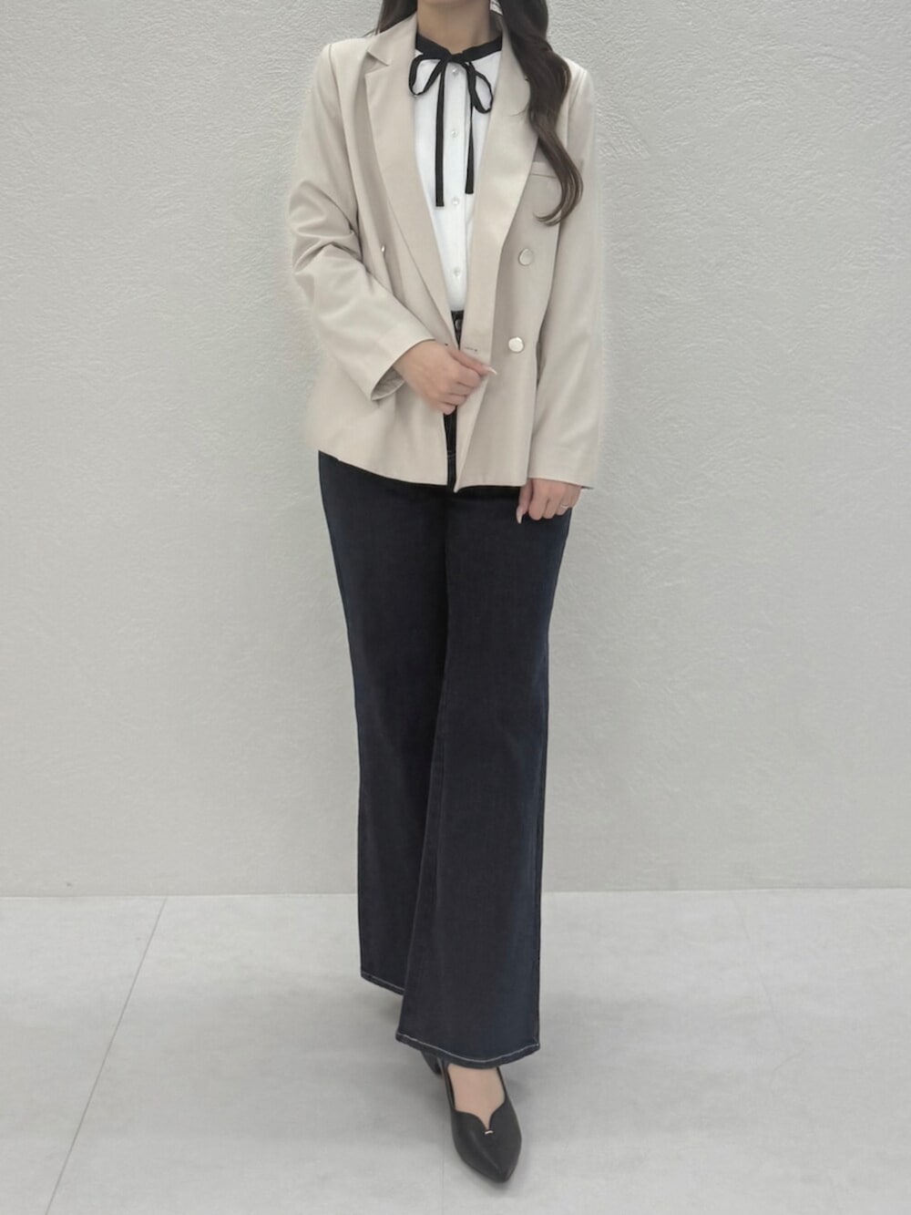 ベージュ系のテーラードジャケット、ブルー系のデニムパンツ、ホワイト系のシャツ/ブラウスを着用したレディースの春コーディネートの3枚目の写真