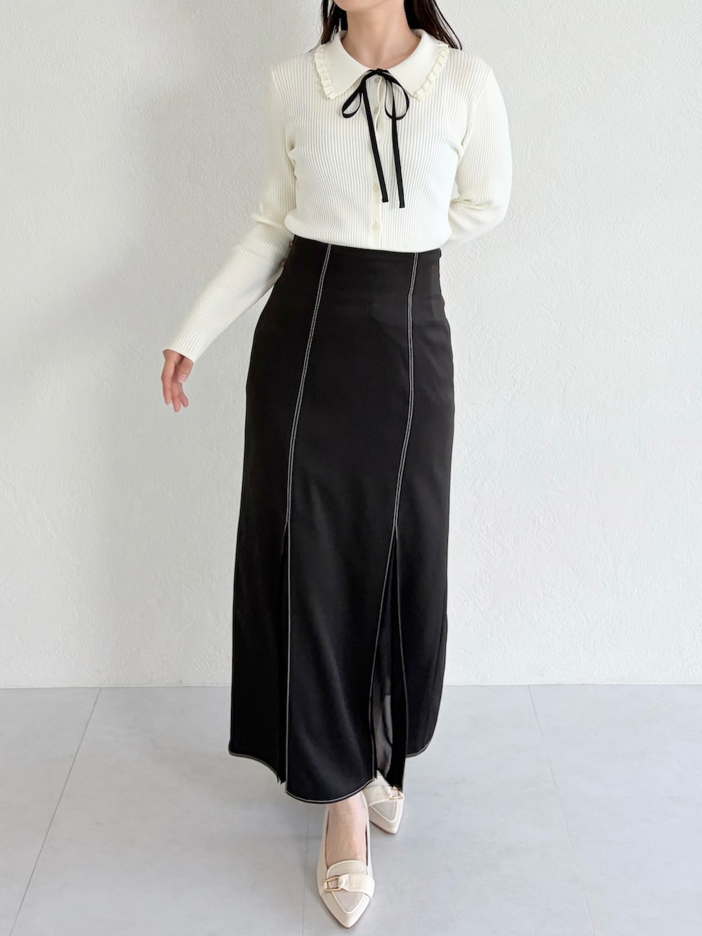 ベージュ系のシューズ、ホワイト系のシャツ/ブラウス、ブラック系のスカートを着用したレディースの春コーディネートの2枚目の写真